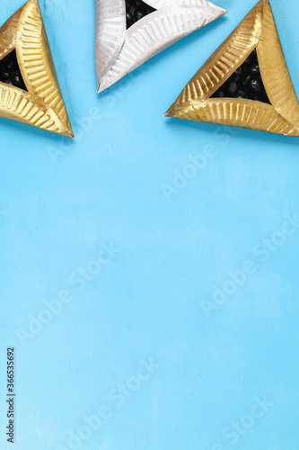Purim. Diy cookies hamantaschen of cardboard plates with sweet surprise inside on blue background