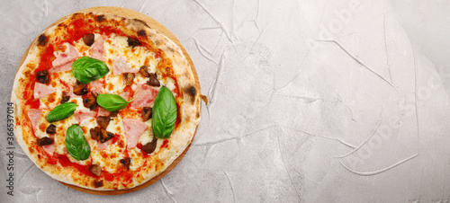pizza with mushrooms and ham banner on light concrete or stone table top view