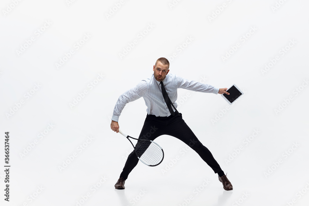 Time for movement. Man in office clothes plays tennis isolated on white studio background. Businessman training in motion, action. Unusual look for sportsman, new activity. Sport, healthy lifestyle. Time for movement. Man in office clothes plays tennis isolated on white studio background. Businessman training in motion, action. Unusual look for sportsman, new activity. Sport, healthy lifestyle.