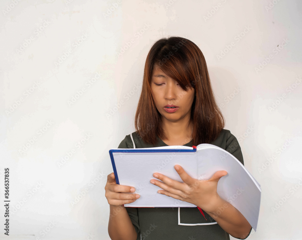 Lady holding book in hand,reading with interested feeling,model posing Lady holding book in hand,reading with interested feeling,model posing