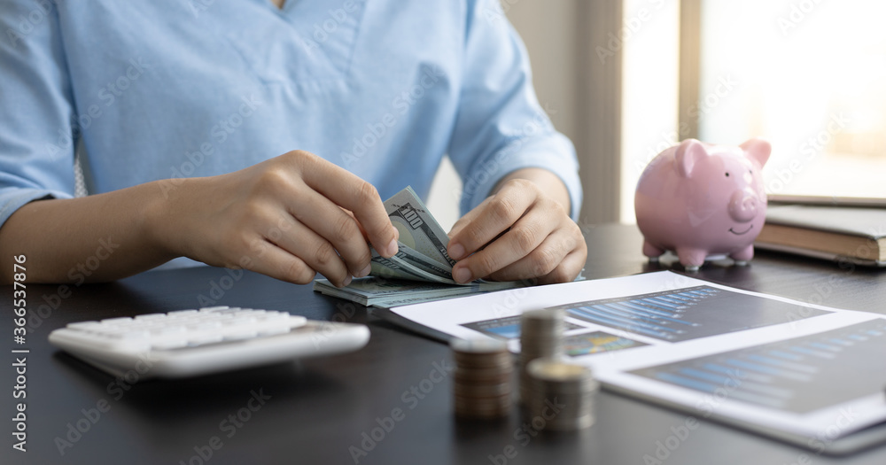 Fototapeta premium Man counting dollar bills on the desk.