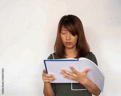 Lady holding book in hand,reading with interested feeling,model posing