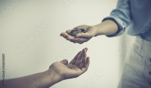 Billede på lærred Hands of the young woman handing the coin to the man