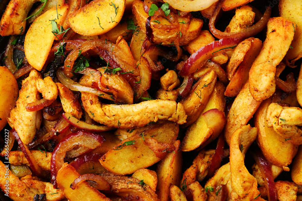 frying pan with potatoes meat and roast onion close up on black concrete background. mexican food concept. potatoes fried in a pan top view. food background. frying pan with potatoes meat and roast onion close up on black concrete background. mexican food concept. potatoes fried in a pan top view. food background.