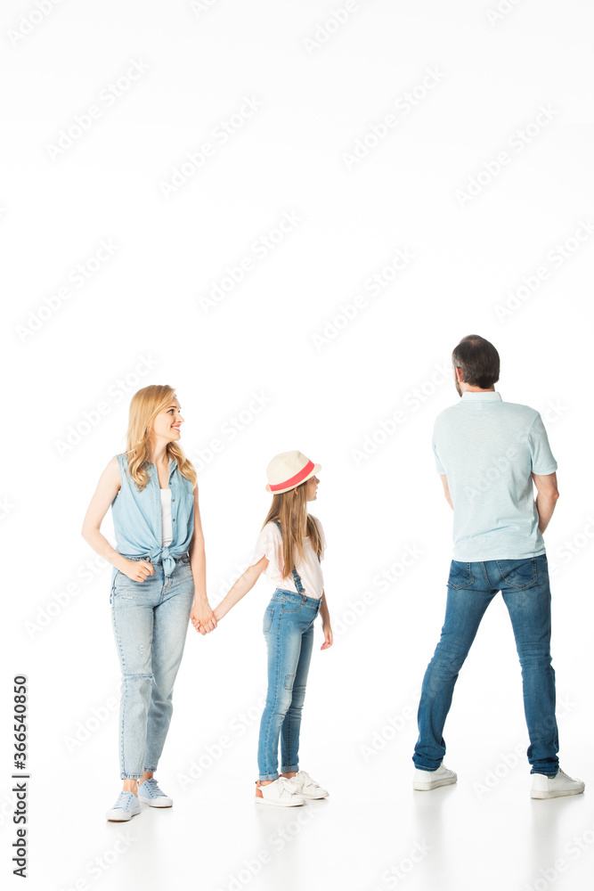 Fototapeta premium full length view of mother and daughter looking at man isolated on white