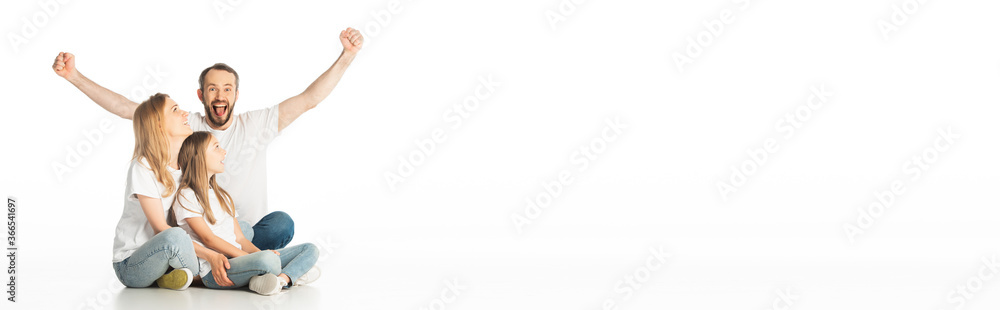 happy family sitting on floor with crossed legs while man showing yes gesture isolated on white, panoramic shot happy family sitting on floor with crossed legs while man showing yes gesture isolated on white, panoramic shot