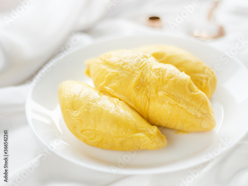 Durian on a Plate on White Background. Durian Side View on Satin Background. Durian on a White Table. Eating durian on the bed.
