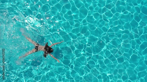 aerial view of young woman swimming breaststroke in the pool photo
