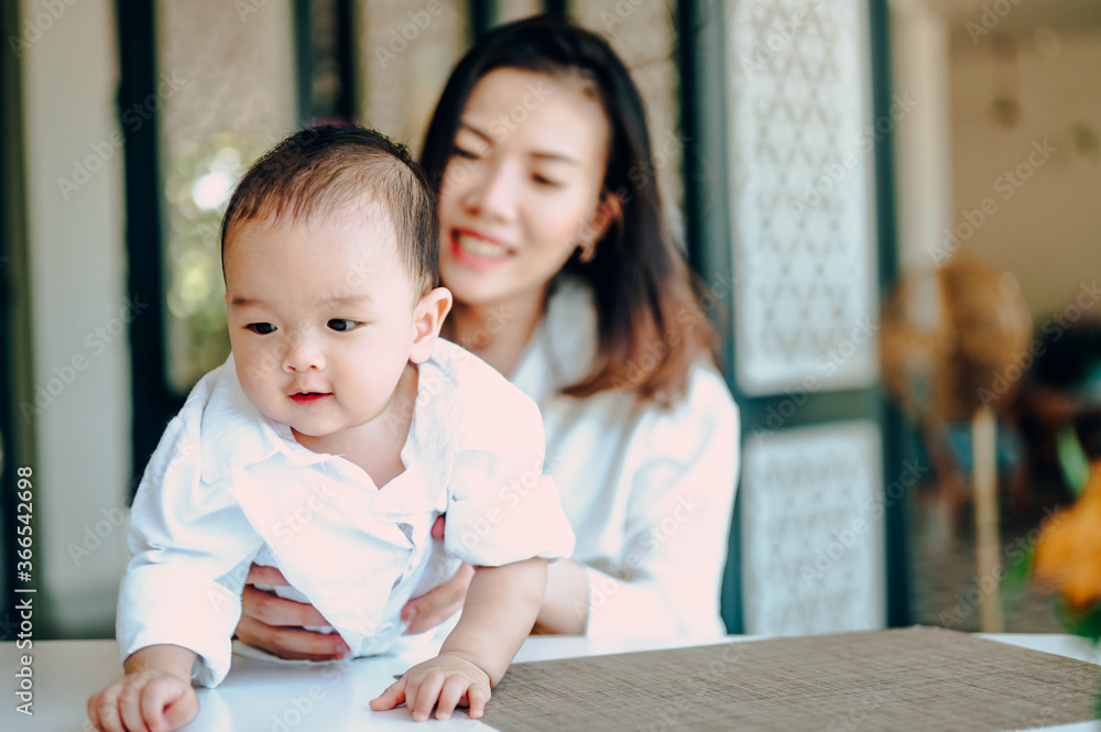 Asian baby boy in white shirt playing with his mother ,Happy family in vacation. Asian baby boy in white shirt playing with his mother ,Happy family in vacation.