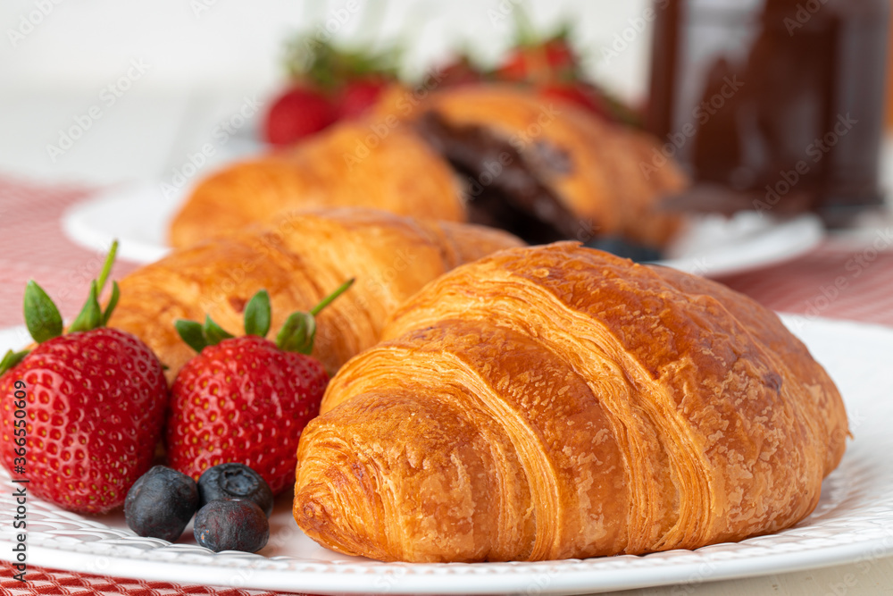 Fresh croissant decorated with berries on white wooden board Fresh croissant decorated with berries on white wooden board