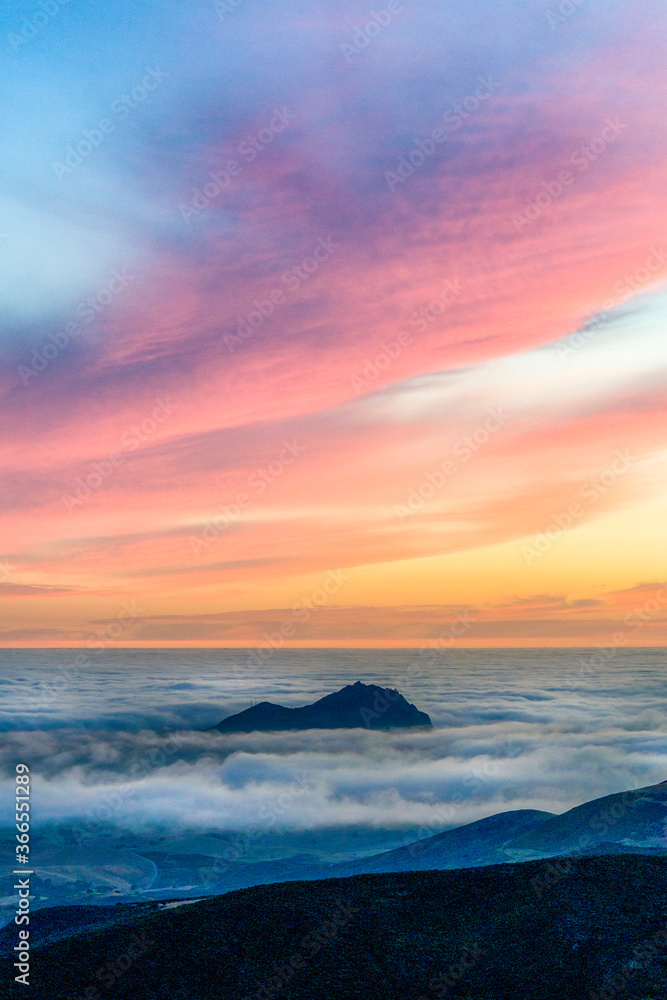 Sunset from a view of Mountain Peak above Clouds