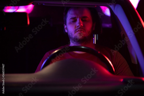 Portrait of man who got into an accident before his arrest. Road police with flashing lights. Drunk driver knocked down a man. Process of arresting the offender. The driver lost consciousness concept.