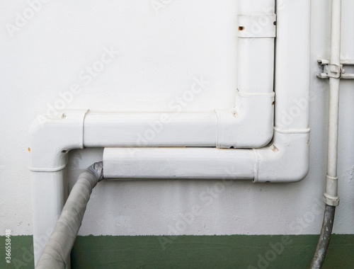 White plastic piping cover the air conditioner system.