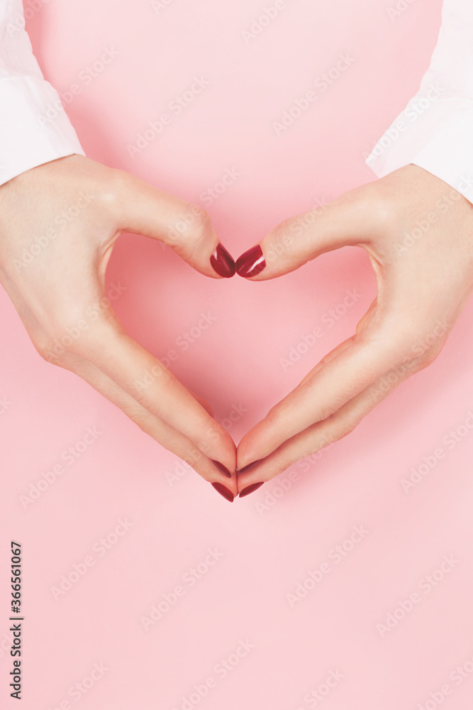 Woman hands in a heart shape on pink background.Woman hands with perfect manicure in a heart shape on pink background. Copy space. Love, happiness and charity concept. Woman hands in a heart shape on pink background.Woman hands with perfect manicure in a heart shape on pink background. Copy space. Love, happiness and charity concept.