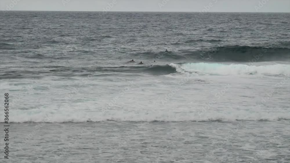 Surfers Enjoying The Rough Sea Waves Rolling In The Ocean In Siargao, Philippines On A Gloomy Day. - wide shot Surfers Enjoying The Rough Sea Waves Rolling In The Ocean In Siargao, Philippines On A Gloomy Day. - wide shot