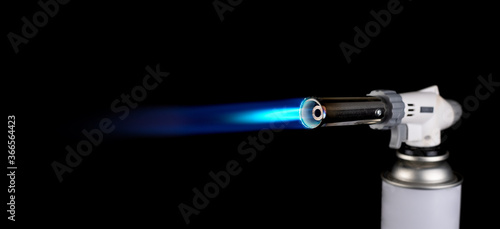 Obraz na plátne Flamethrower burner gas blow torch Ignition with blue fire flame at black backgr