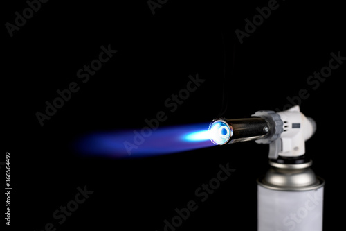 Obraz na plátne Flamethrower burner gas blow torch Ignition with blue fire flame at black backgr