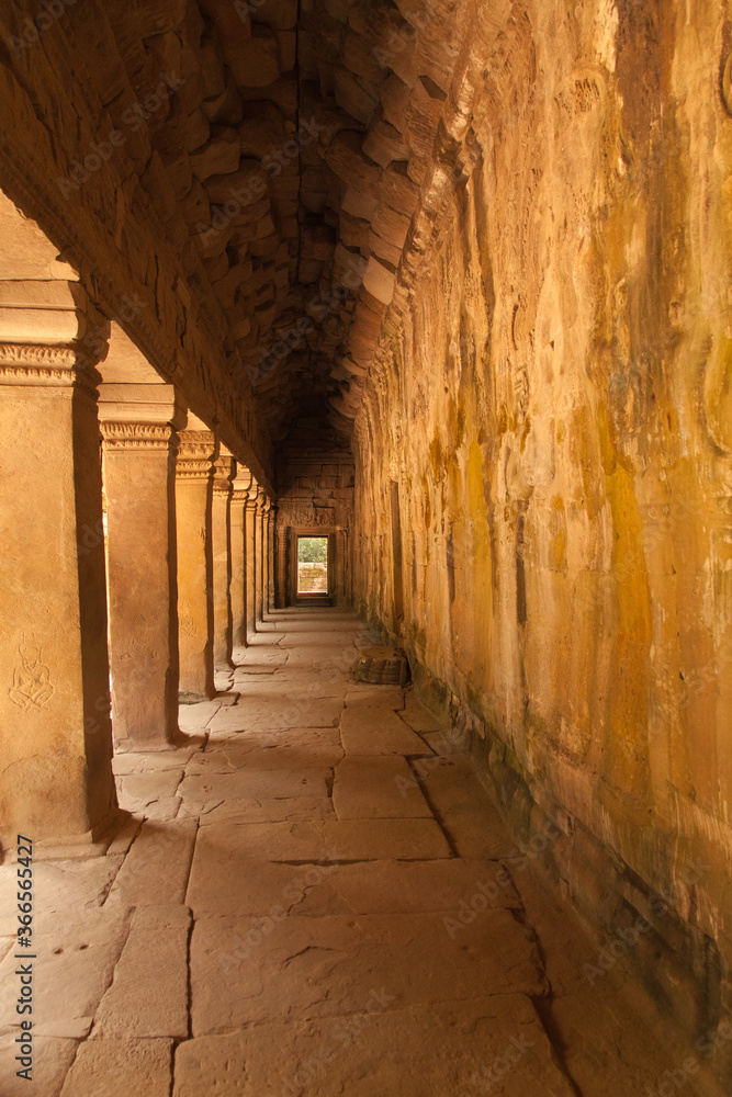 Fototapeta premium The temples of Angkor Watt, Cambodia, golden passageway with repeating arches