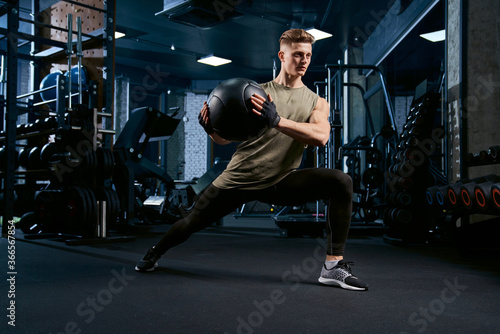 Sportsman doing lunges using ball.