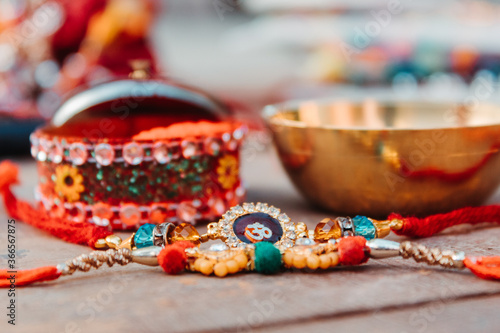 Indian festival: Raksha Bandhan background with an elegant Rakhi, Rice Grains and Kumkum. A traditional Indian wrist band which is a symbol of love between Brothers and Sisters.