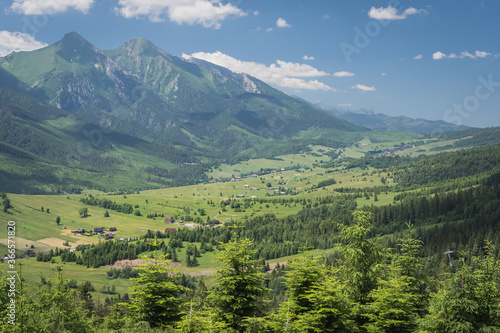 Beautiful elevated view of mountains in Slovakia. Bachledova dolina, Zdiar village and Belianske Tatry mountains seen from an elevated viewpoint on a hiking trail on summer day