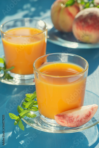  Fresh juice and peaches on a blue table