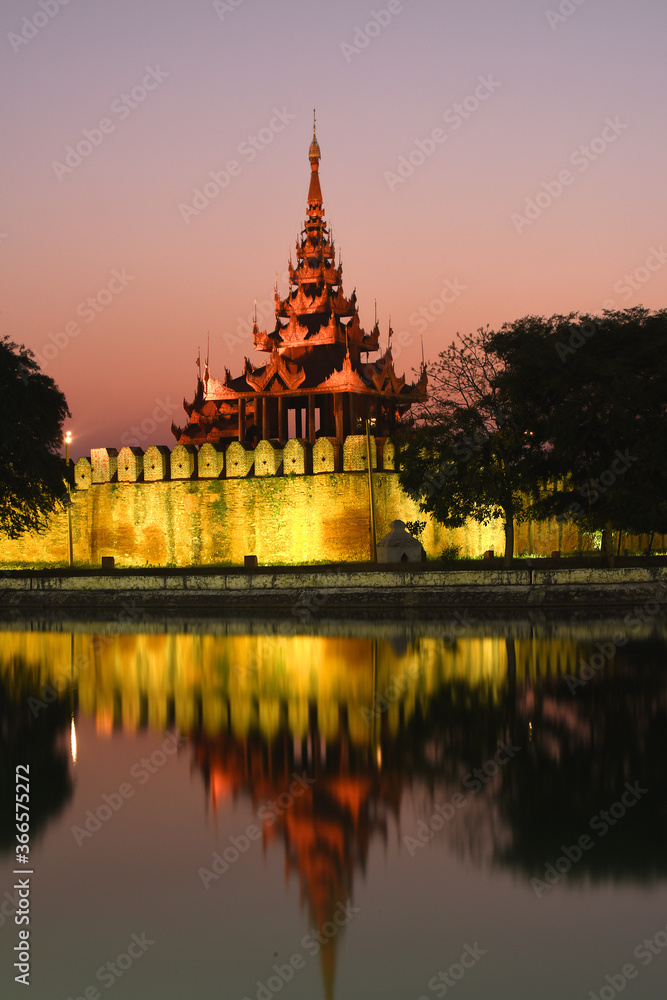 Night view to the illuminated walls of the Fort or Royal Palace with ancient watchtower in Mandalay, Myanmar (Burma) 