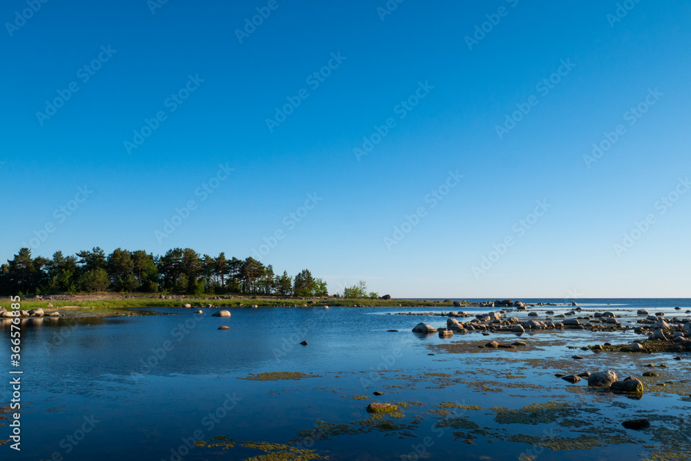 Сoast filled with small stones mixed with grass.