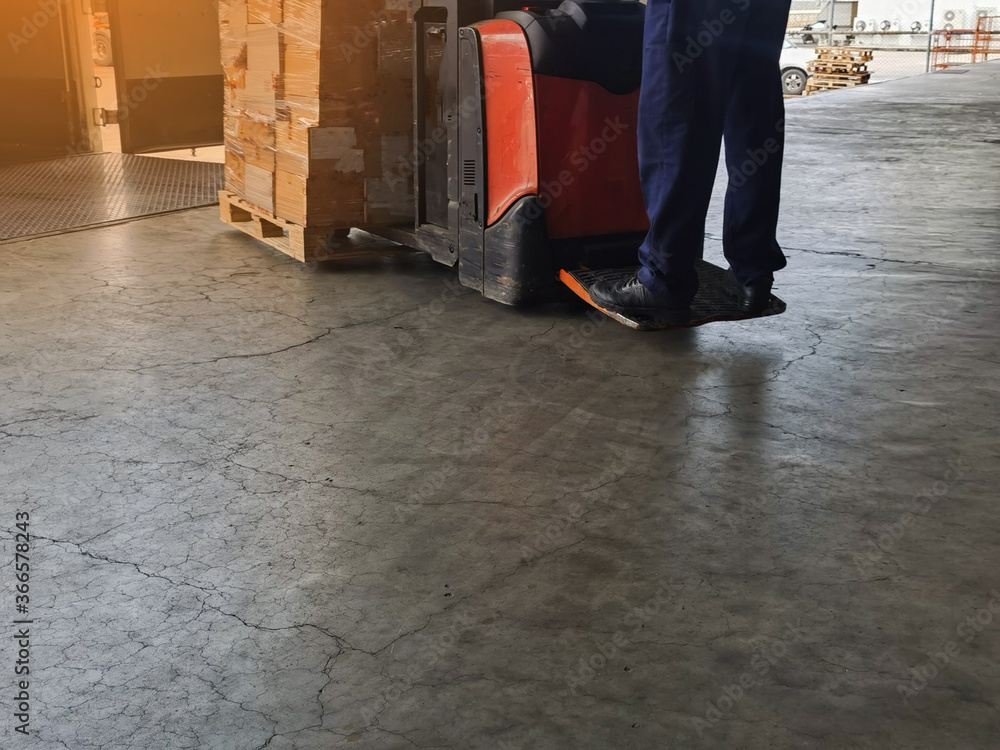Worker driving forklift loading and unloading shipment carton boxes and goods on wooden pallet from container truck to warehouse cargo storage in logistics and transportation industrial Worker driving forklift loading and unloading shipment carton boxes and goods on wooden pallet from container truck to warehouse cargo storage in logistics and transportation industrial