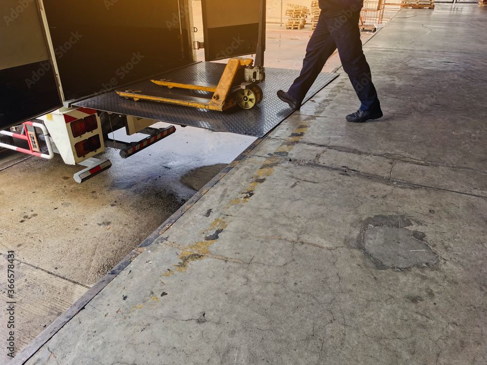 Worker driving forklift loading and unloading shipment carton boxes and goods on wooden pallet from container truck to warehouse cargo storage in logistics and transportation industrial Worker driving forklift loading and unloading shipment carton boxes and goods on wooden pallet from container truck to warehouse cargo storage in logistics and transportation industrial