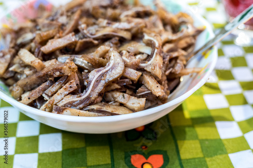 A cooked dish made from pork ears. Delicacy. The dish is on our table.