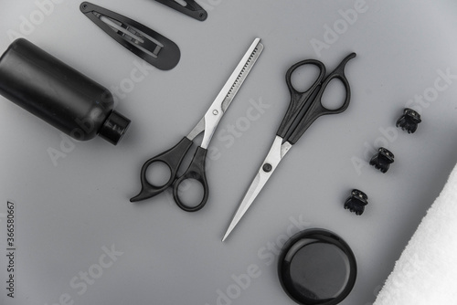 Professional hair dresser tools with copy space. Hair stylist equipment set on gray background. Scissors  brush  hairbrush  balm flat lay top view.