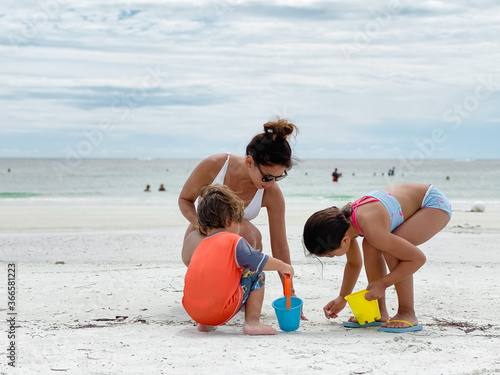 Obraz na plátně children and mom playing on the beach in Marco island by the JW marriott resort