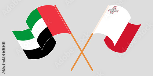 Crossed and waving flags of Malta and United Arab Emirates
