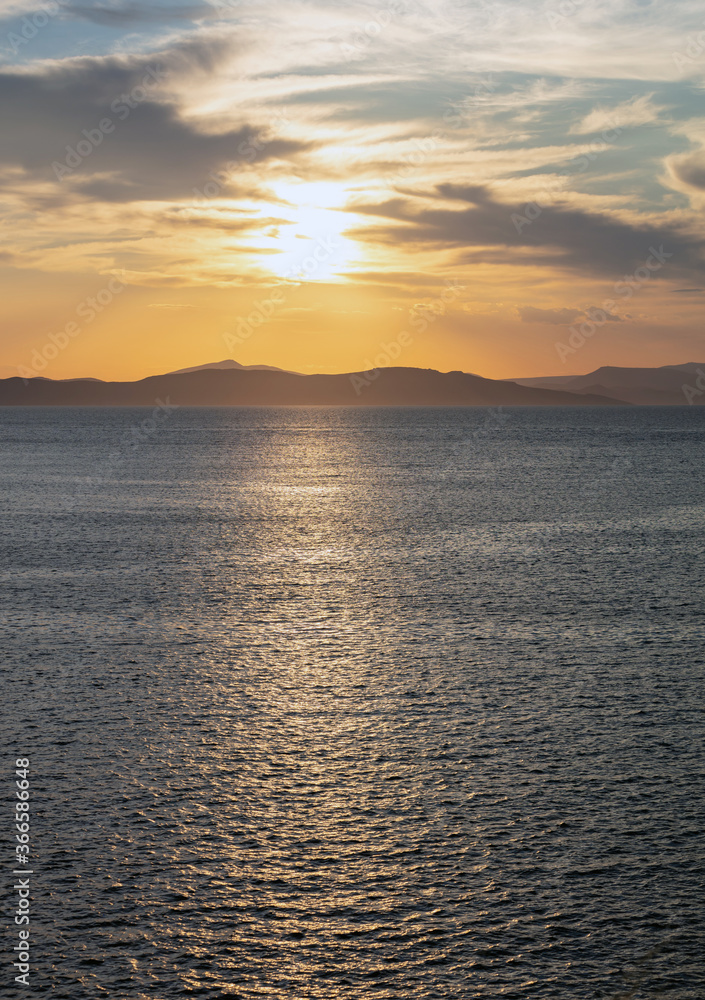Sunrise, sunset clouds. Twilight, dusk cloudy sky over sea water, mountain silhouette Sunrise, sunset clouds. Twilight, dusk cloudy sky over sea water, mountain silhouette