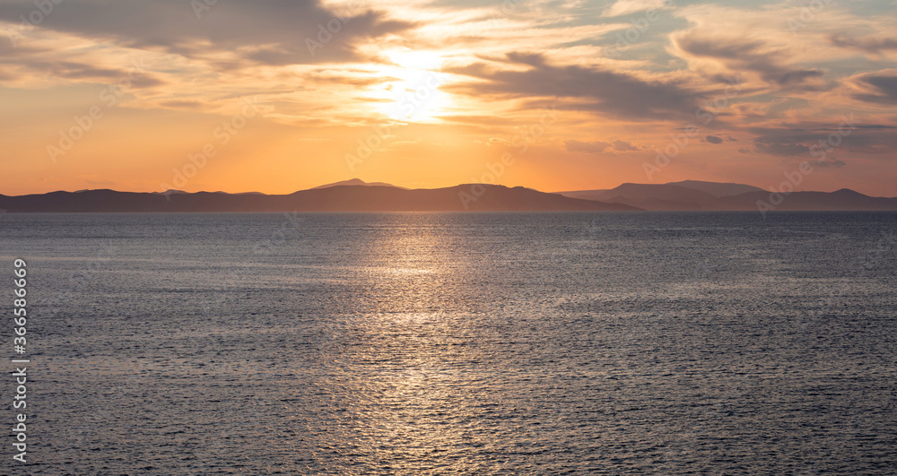 Sunrise, sunset clouds. Twilight, dusk cloudy sky over sea water, mountain silhouette Sunrise, sunset clouds. Twilight, dusk cloudy sky over sea water, mountain silhouette