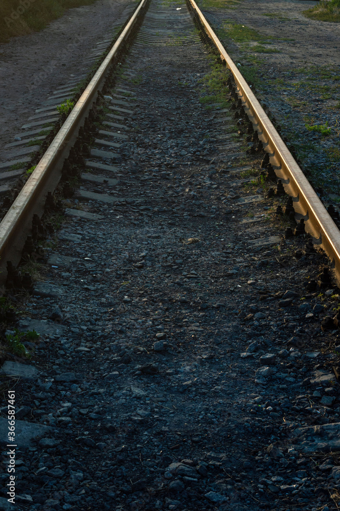 Obraz premium Railway rails in sunset. Railway in Ukraine. railway transport. Movement. Tourism. The concept of the way forward. Industrial background with the ability to apply a piece of text