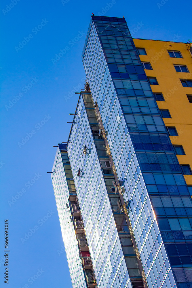 New block of modern apartments with balconies and blue sky background, free space for text