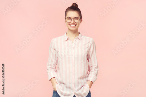 Quadro em tela Young smiling student girl dressed in shirt and jeans, wearing round glasses and