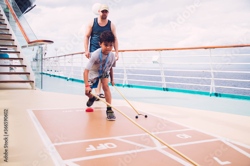 father and son playing shuffleboard on cruise ship  photo