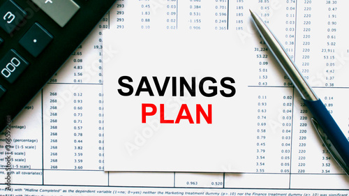 Work smarter text Savings Plan on white sheet with pen, calculator and tables