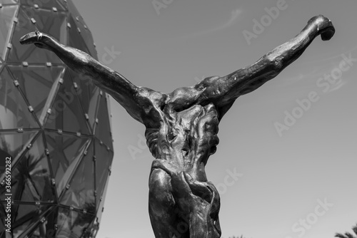 Black and white photo showing perspective of the back of metal statue representing the body of crucified Jesus 