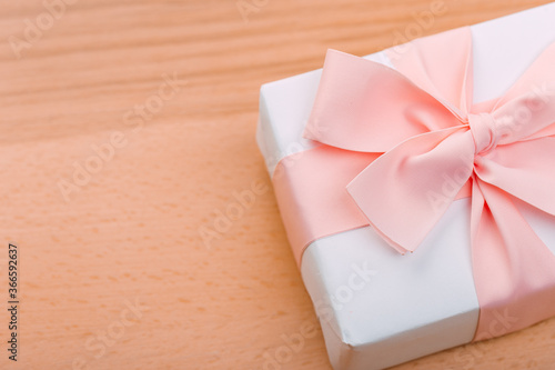 Beautiful gift box with altas bow on a vintage wooden board. holiday card concept.