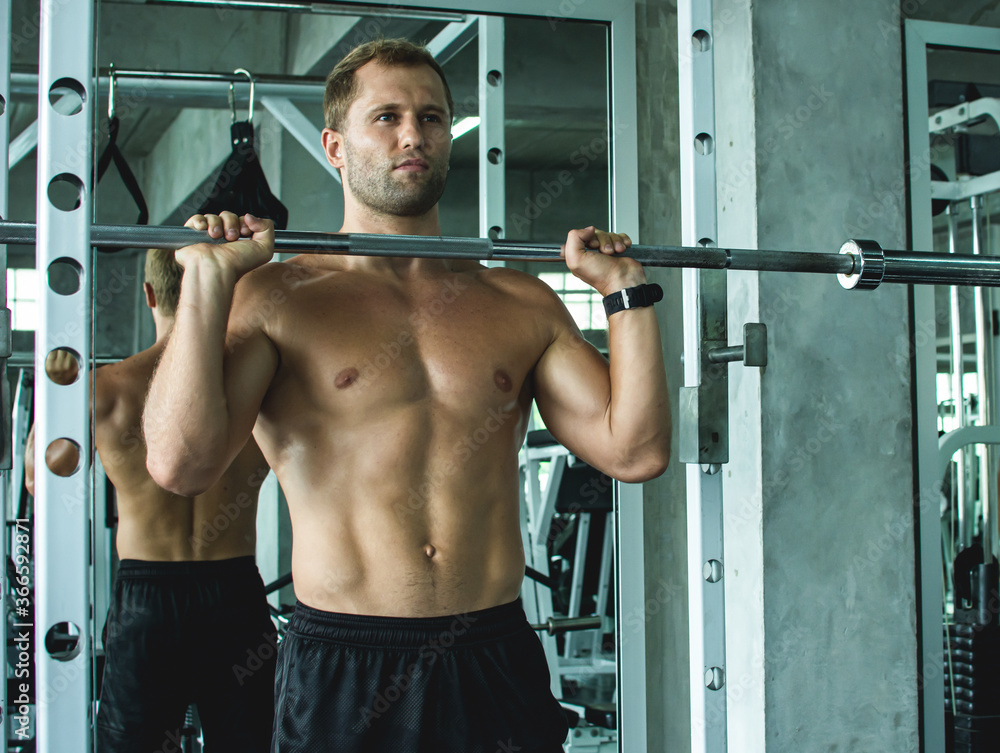 Muscular man doing exercise in gym Muscular man doing exercise in gym