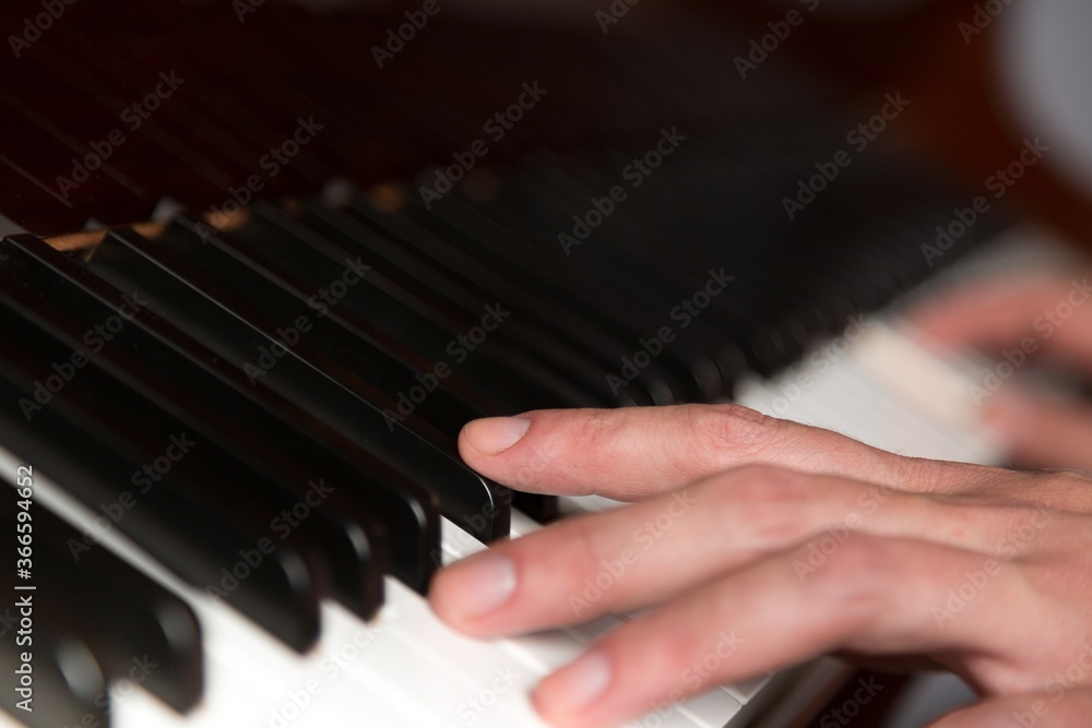 Obraz premium Hands on Piano Keyboard - Close Up