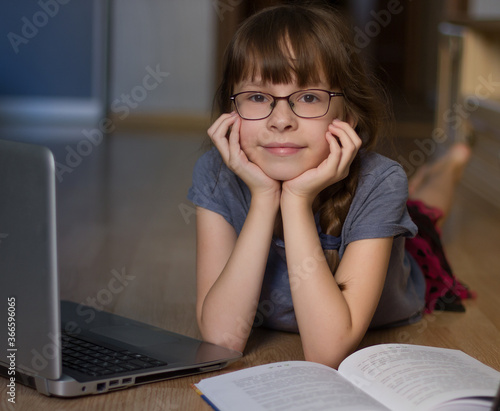10 years old girl reading and study at home by internet