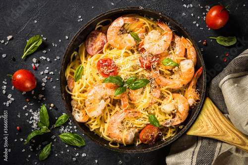 Pasta seafood with shrimp on black table.