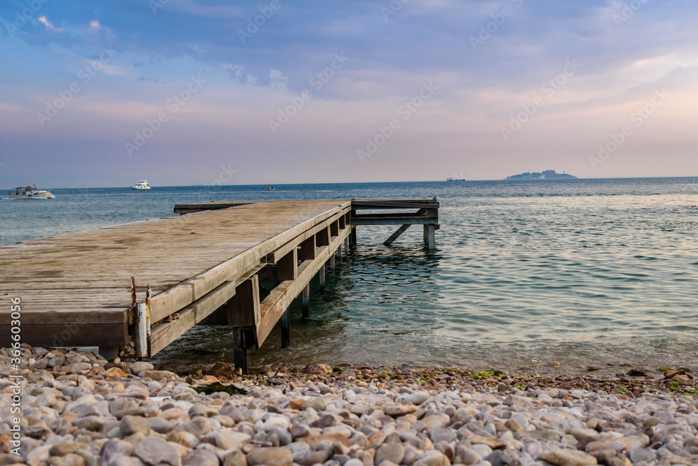 an old wooden pier stretches into the open sea