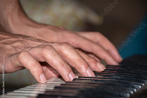 extreme closeup scene of a man playing piano, hands only.
