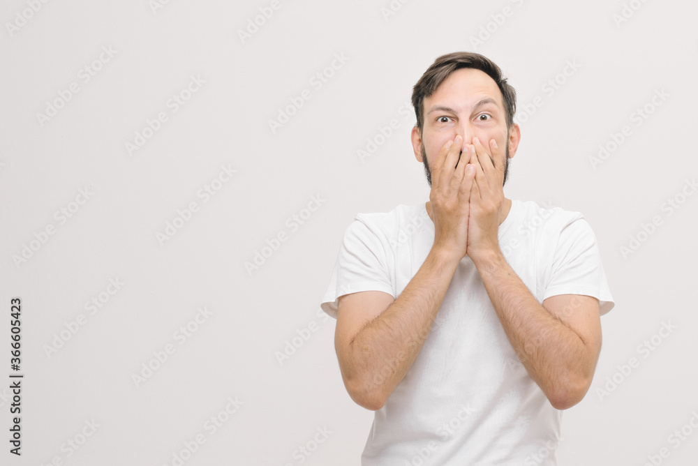 close portrait. young man covers his mouth with his palms close portrait. young man covers his mouth with his palms